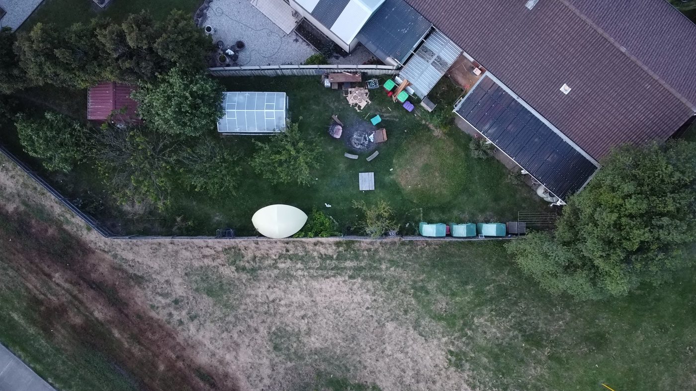 Aerial view of a rural block with house, solar panels and water tanks