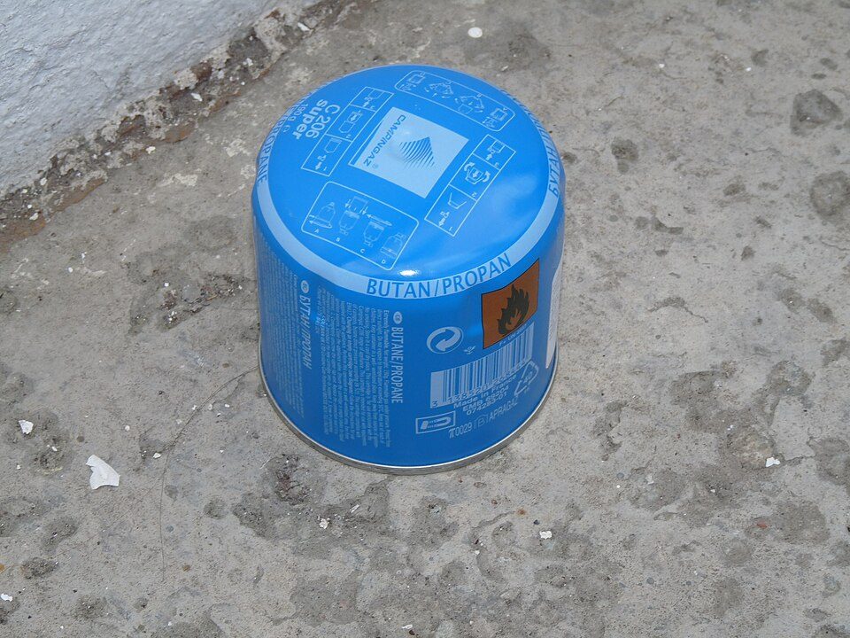 Blue campingaz butanepropane gas cylinder on concrete surface.